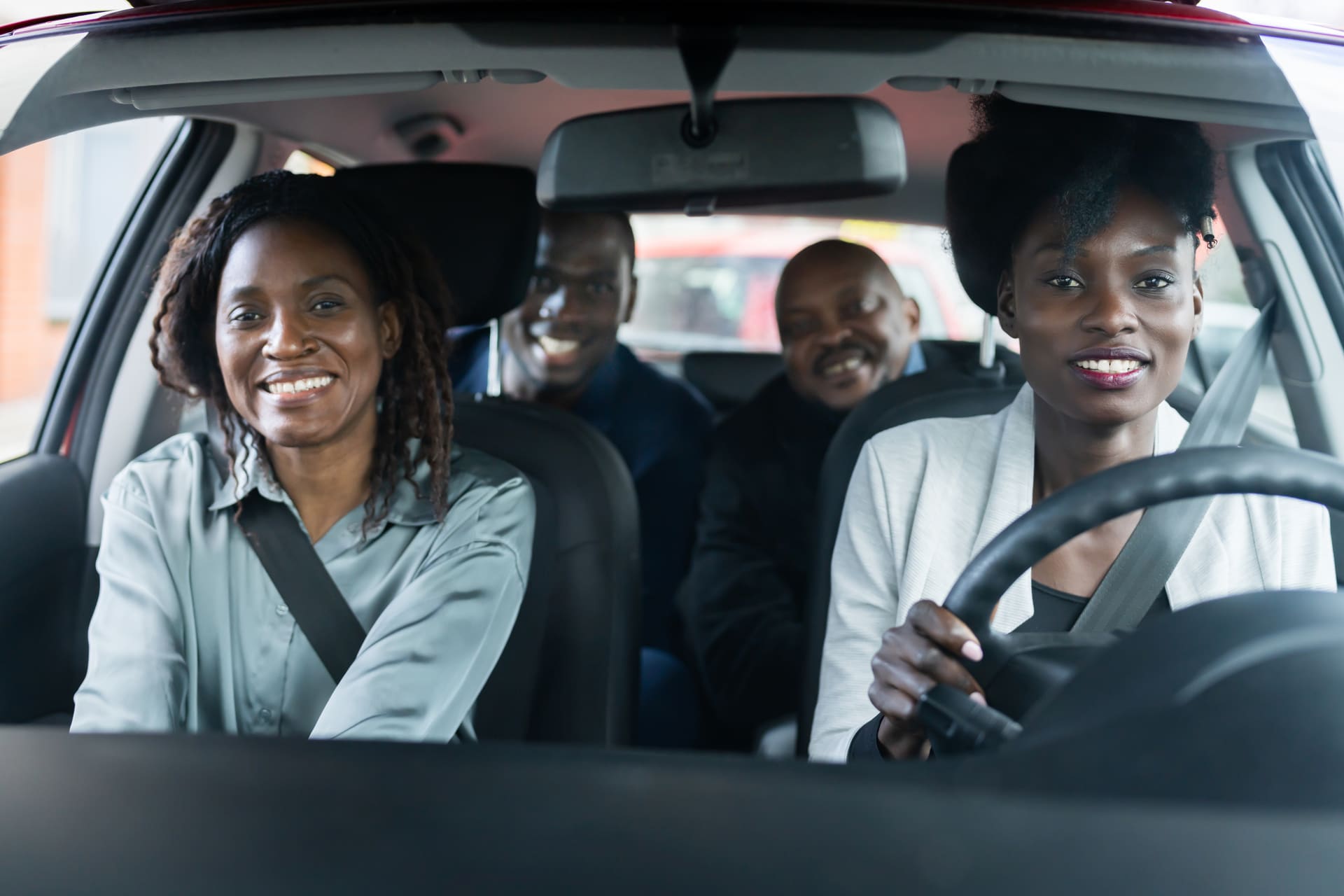 Four commuters in a car with seatbelts on a scheduled corridor route