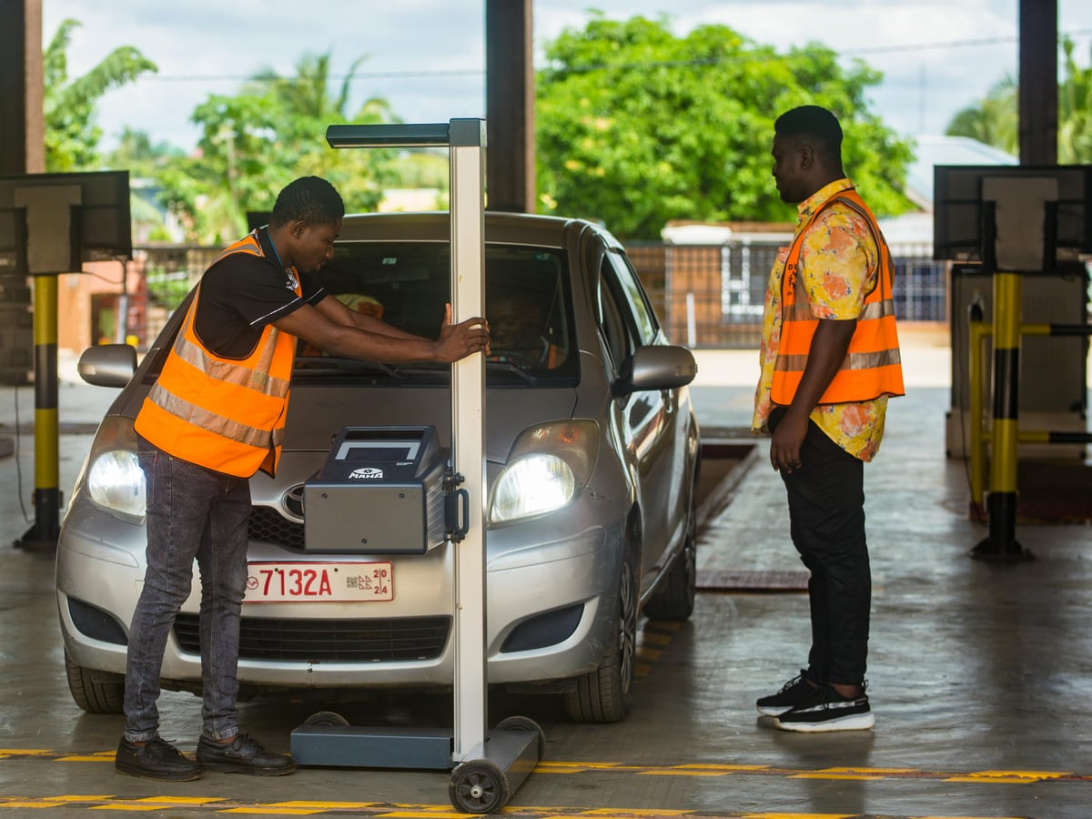 Trained QuickLyft inspection agents at an inspection centre running a hands-on physical check on a private sedan